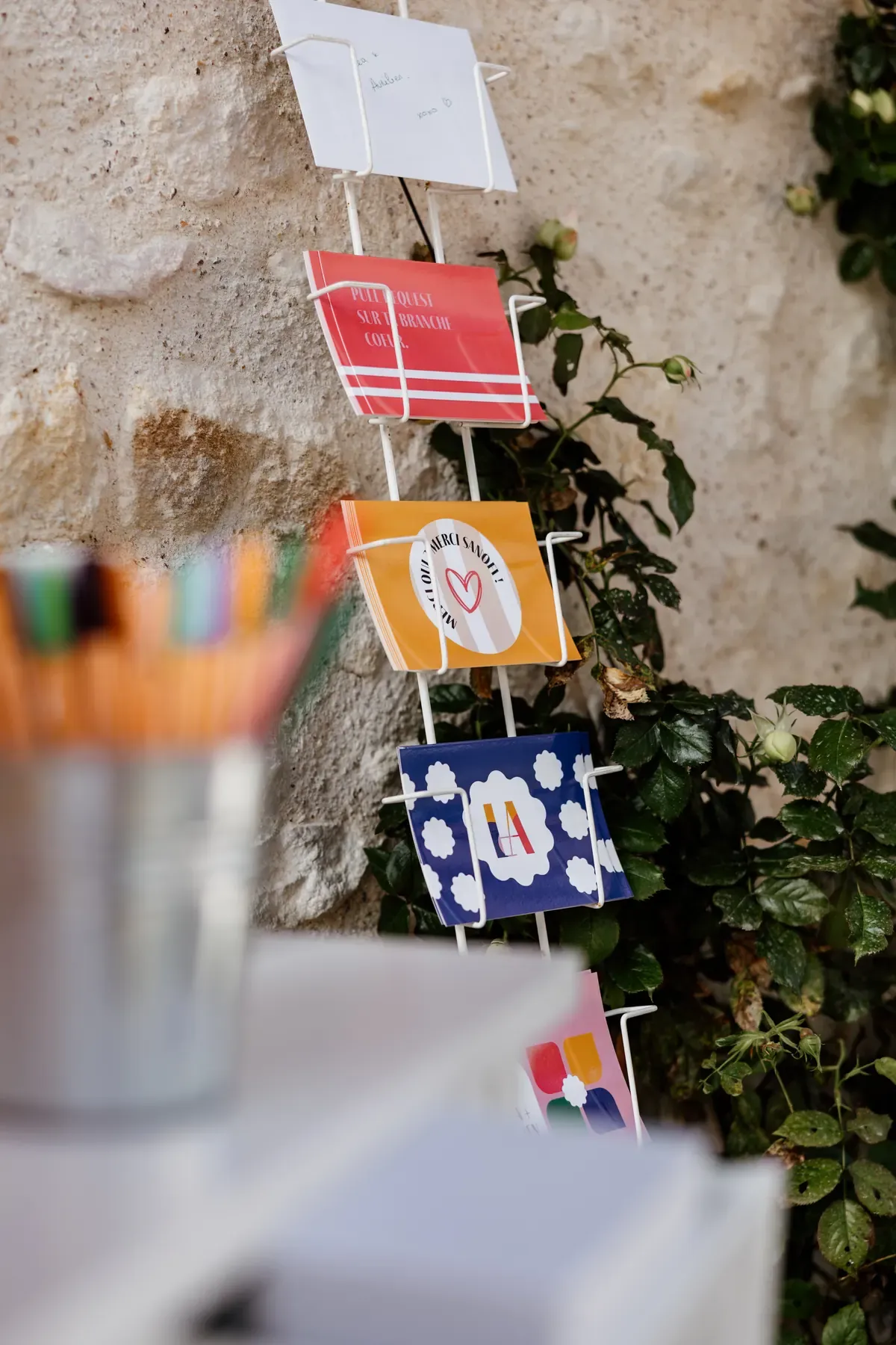 Wall rack holding message cards in the identity's colours and patterns