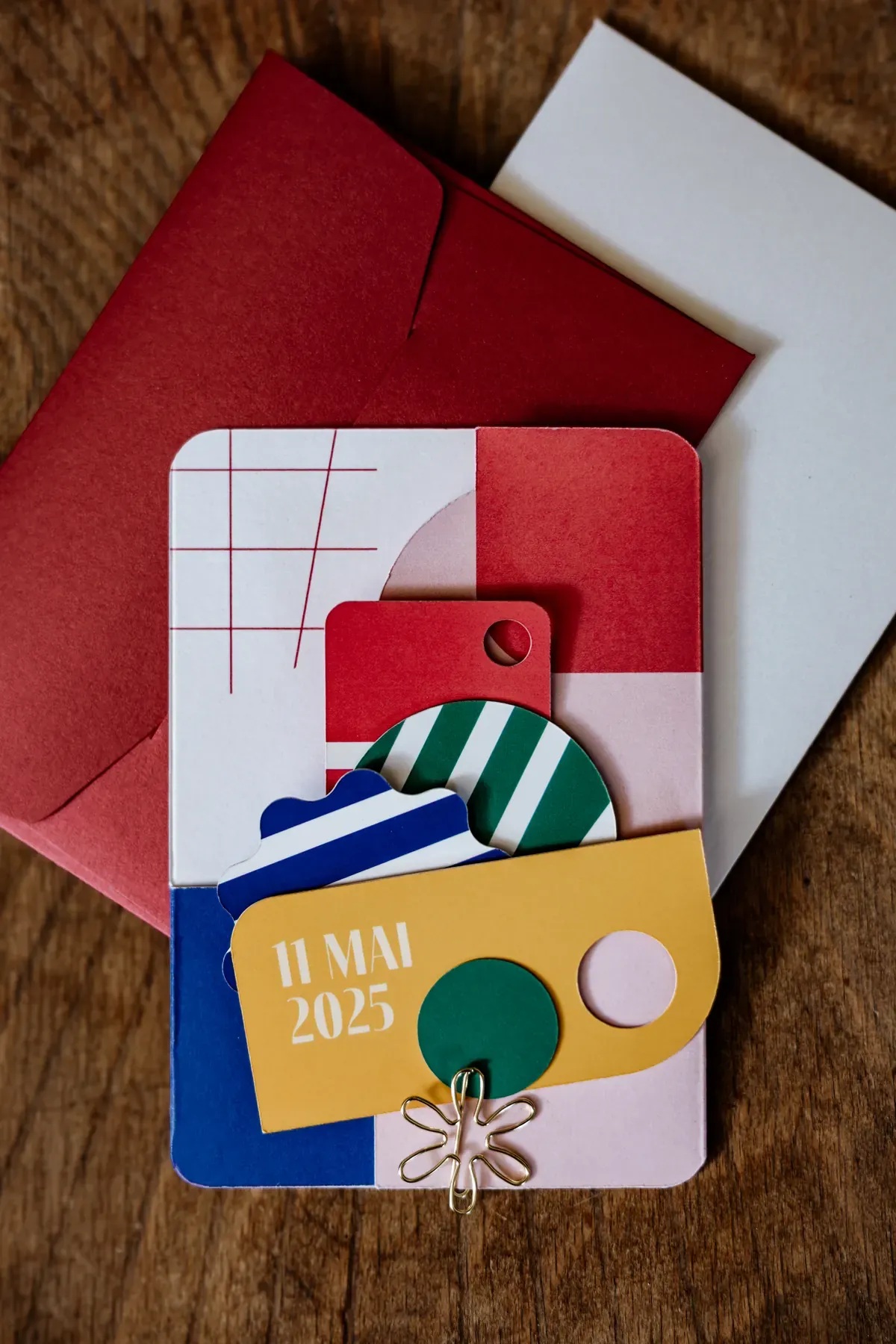 Invitation suite of layered printed cards and coloured envelopes