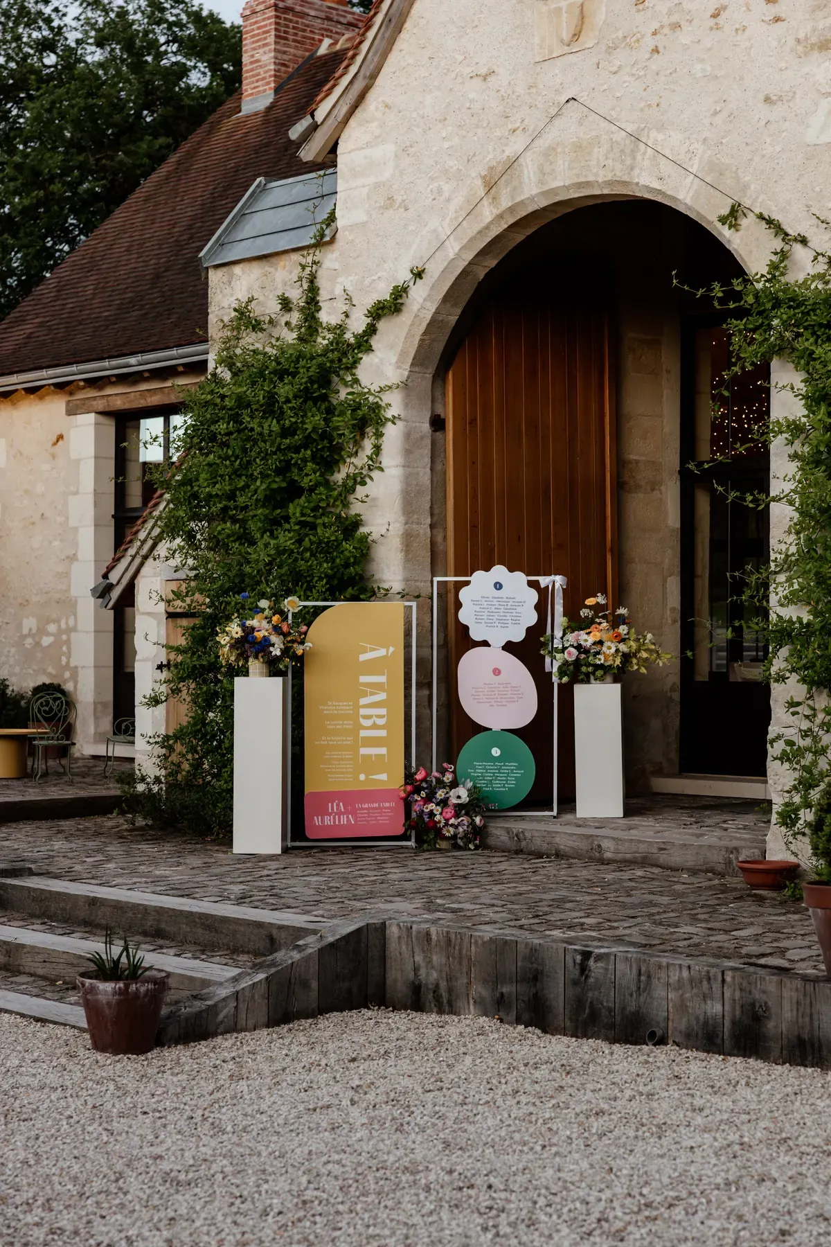 The seating panels installed at the venue doorway at dusk, flanked by floral columns